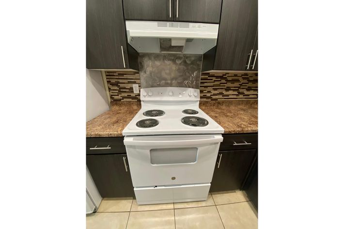 a stove top oven sitting next to a sink