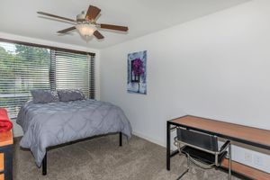 a bedroom with a bed and desk in a small room