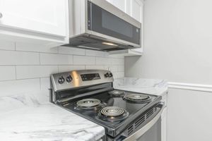 a stove top oven sitting inside of a kitchen