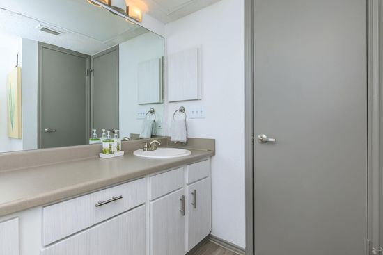 BRIGHT BATHROOM WITH MANY CUPBOARDS AND LONG COUNTER 