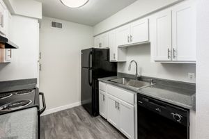 Kitchen equipped with black appliances and deep basin sink at Azul Apartments in Phoenix, Arizona