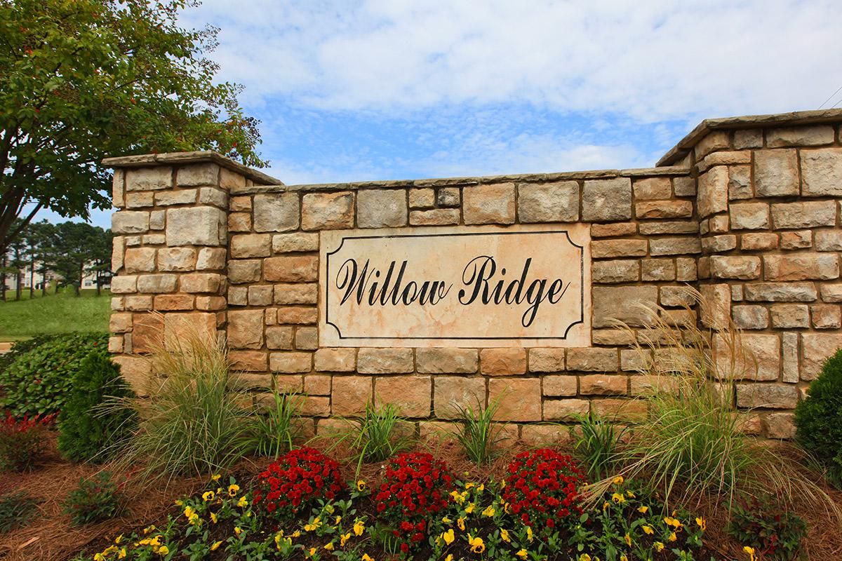 a stone sign in front of a brick wall