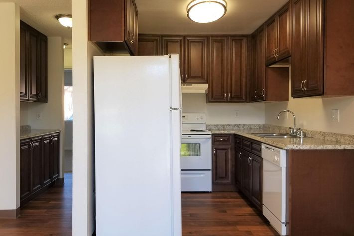 a large kitchen with stainless steel appliances and wooden cabinets