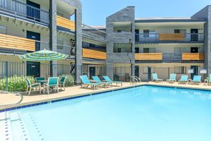 Resort style outdoor pool under a 3 story apartment building