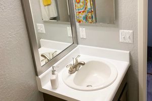 a sink sitting under a mirror