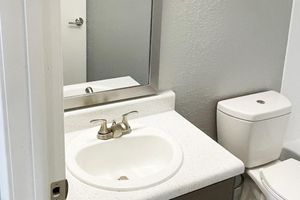 a sink sitting under a mirror
