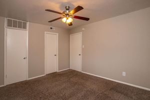 vacant carpeted bedroom with closed doors