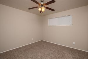 unfurnished carpeted bedroom with a ceiling fan