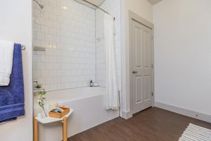 a furnished shower with white tiles