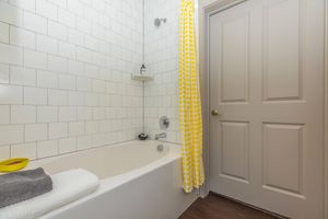 a shower with a yellow shower curtain