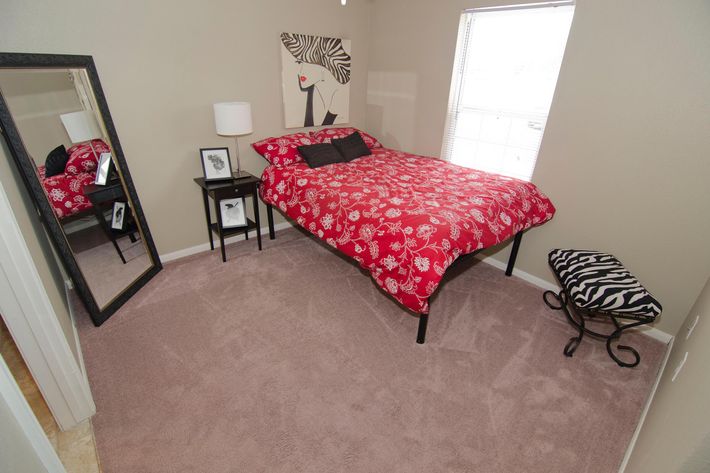 a bedroom with a red rug