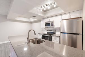 Brand new modern renovated kitchen with grey quartz countertops and white shaker cabinets