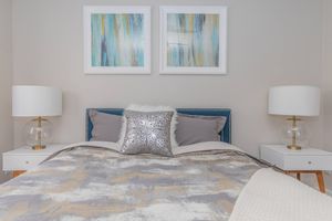 Large bed with 2 side tables and art above the bed