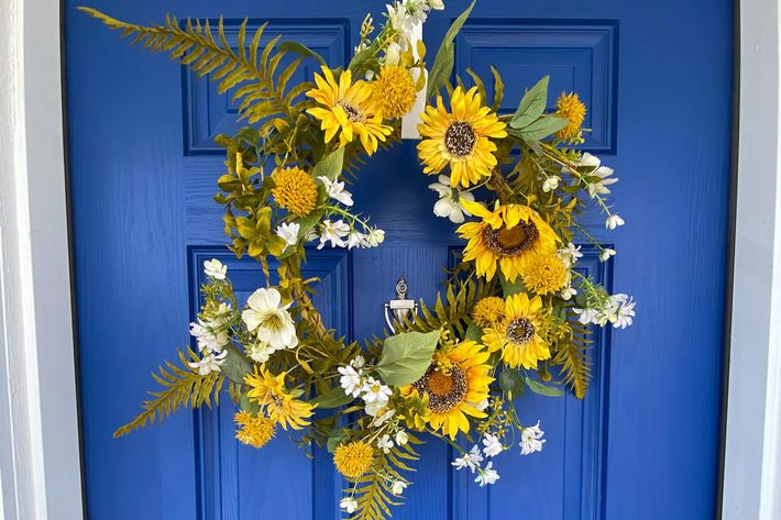 a vase of flowers sits in front of a blue door