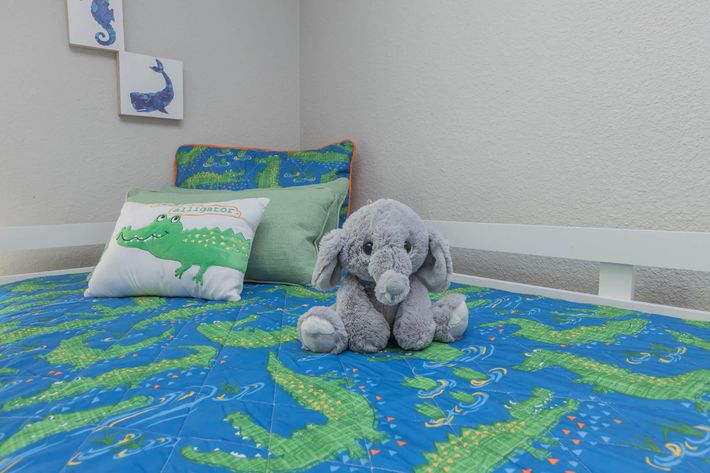 a blue teddy bear sitting on top of a bed