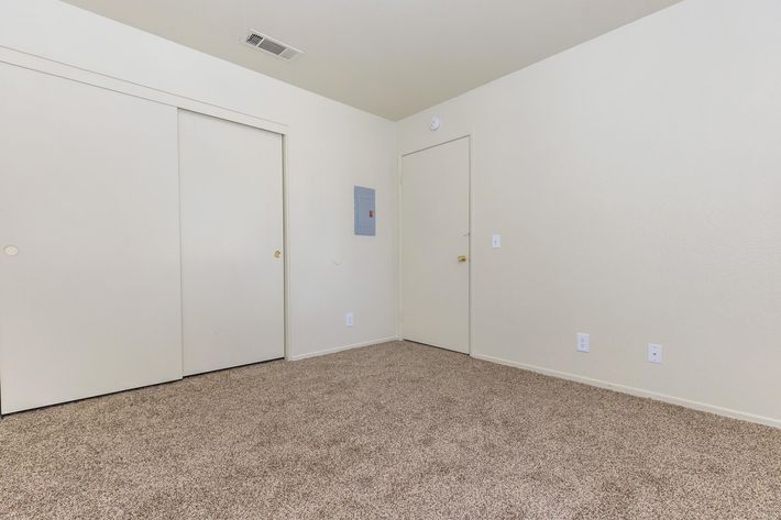 Unfurnished carpeted bedroom with closed sliding closet doors