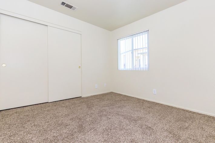 Unfurnished bedroom with closed closet doors with carpet