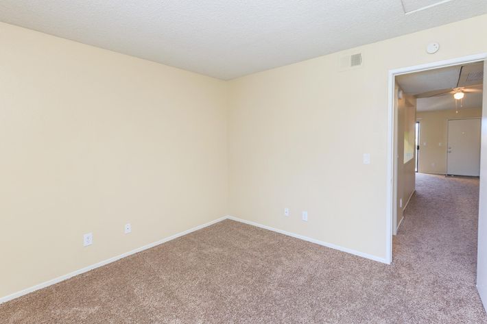 Vacant bedroom and hallway with carpet