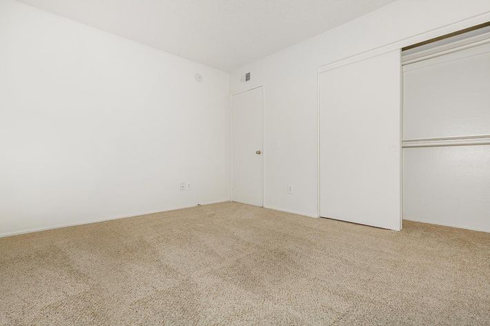 Unfurnished bedroom with carpet and open sliding closet door