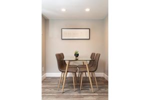 Glass dining room table with four grey chairs