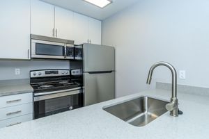 Renovated kitchen with sink built into a granite island countertop