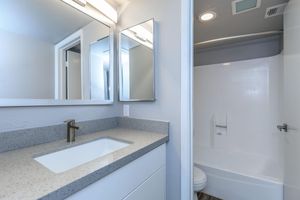 Renovated bathroom with granite vanity and separate shower and toilet room