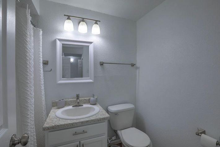a small rest room with a sink and a mirror