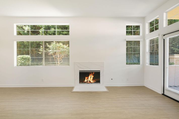 a living room with a fireplace and a large window