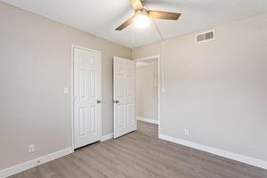bright open bedroom  with doorway, closet, and ceiling fan