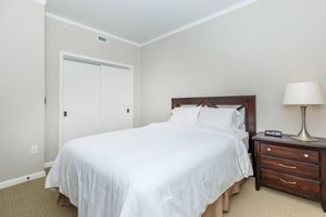a bedroom with a bed and desk in a hotel room