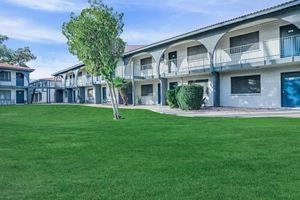 Large exterior apartment building with. large lot of grass in the front