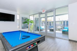 Indoor clubhouse area with a pool table and flat screen tv