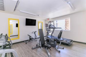 Modern indoor fitness center with gym equipment and a large window