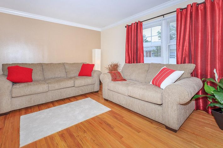 a living room filled with furniture and a red curtain