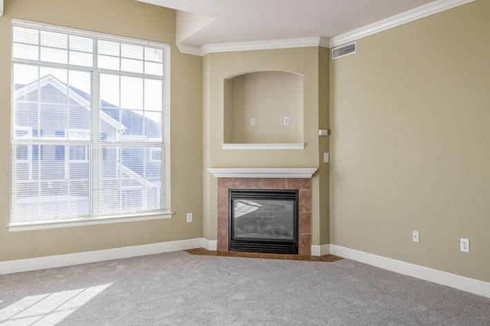 a room with a fireplace and a large window