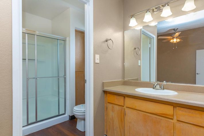 a white sink sitting under a large mirror