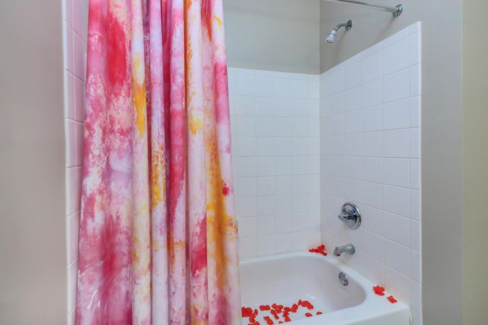 a close up of pink tub and shower curtain