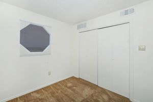 carpeted bedroom with sliding closet doors