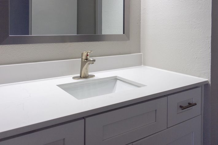 a counter with a sink and a mirror