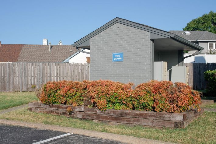 a large brick building with grass in front of a house