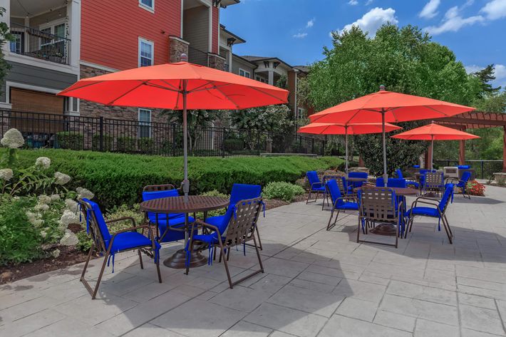 a group of lawn chairs sitting on a table with a blue umbrella