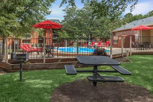Picnic table - barbecue grill in grassy area by the pool 