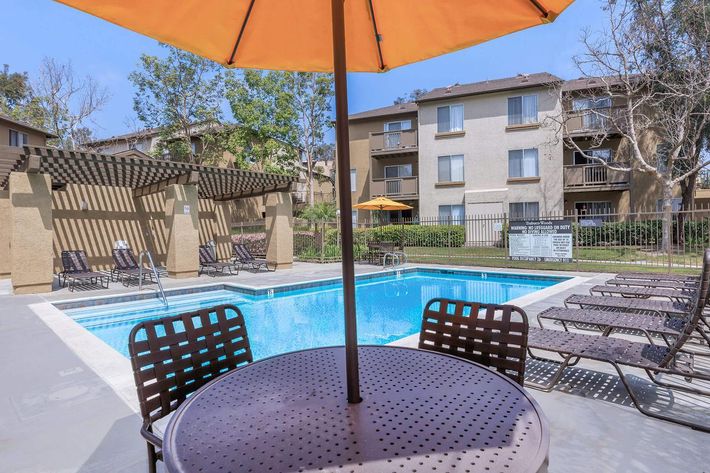 Trabuco Woods Apartment Homes community pool with yellow umbrella