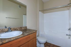 a large white tub next to a sink and a mirror