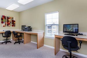 a desk with a computer and a chair in a room