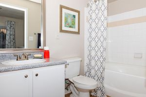 furnished bathroom with white cabinets