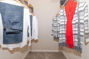 furnished walk-in closet with clothes