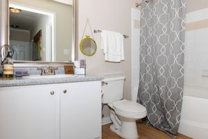 furnished bathroom with a grey shower curtain