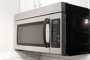 a microwave oven sitting on top of a refrigerator