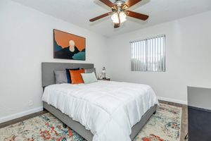 Modern colorful bedroom with small window and ceiling fan